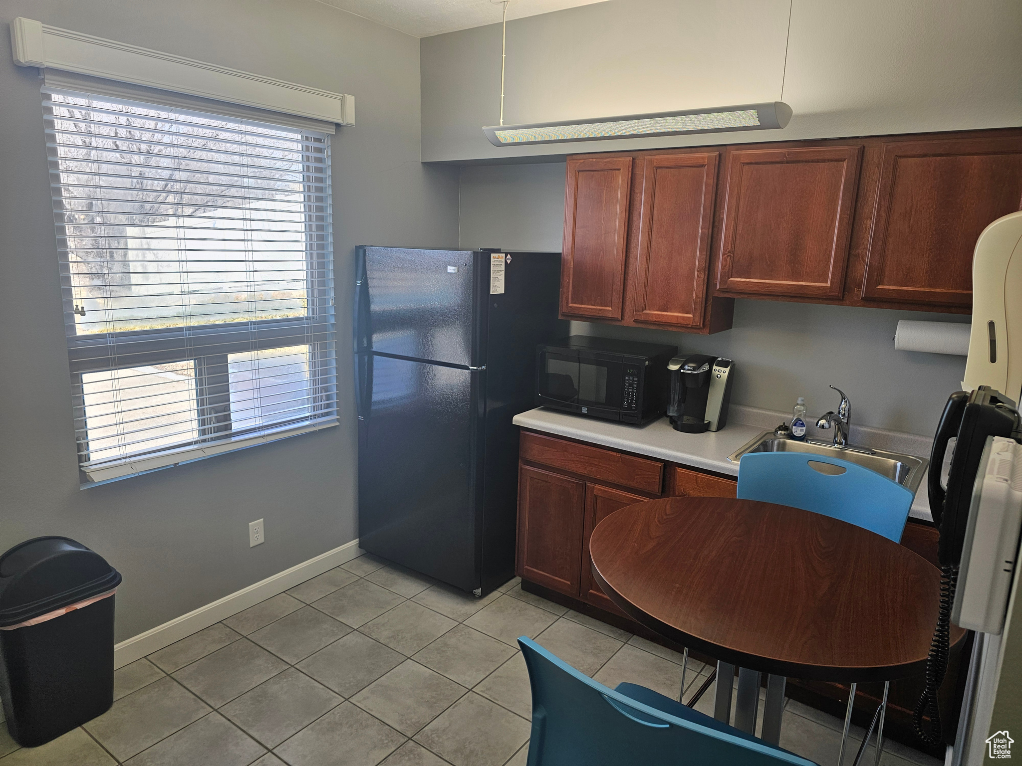 Kitchen featuring sink, black appliances, and light tile floors