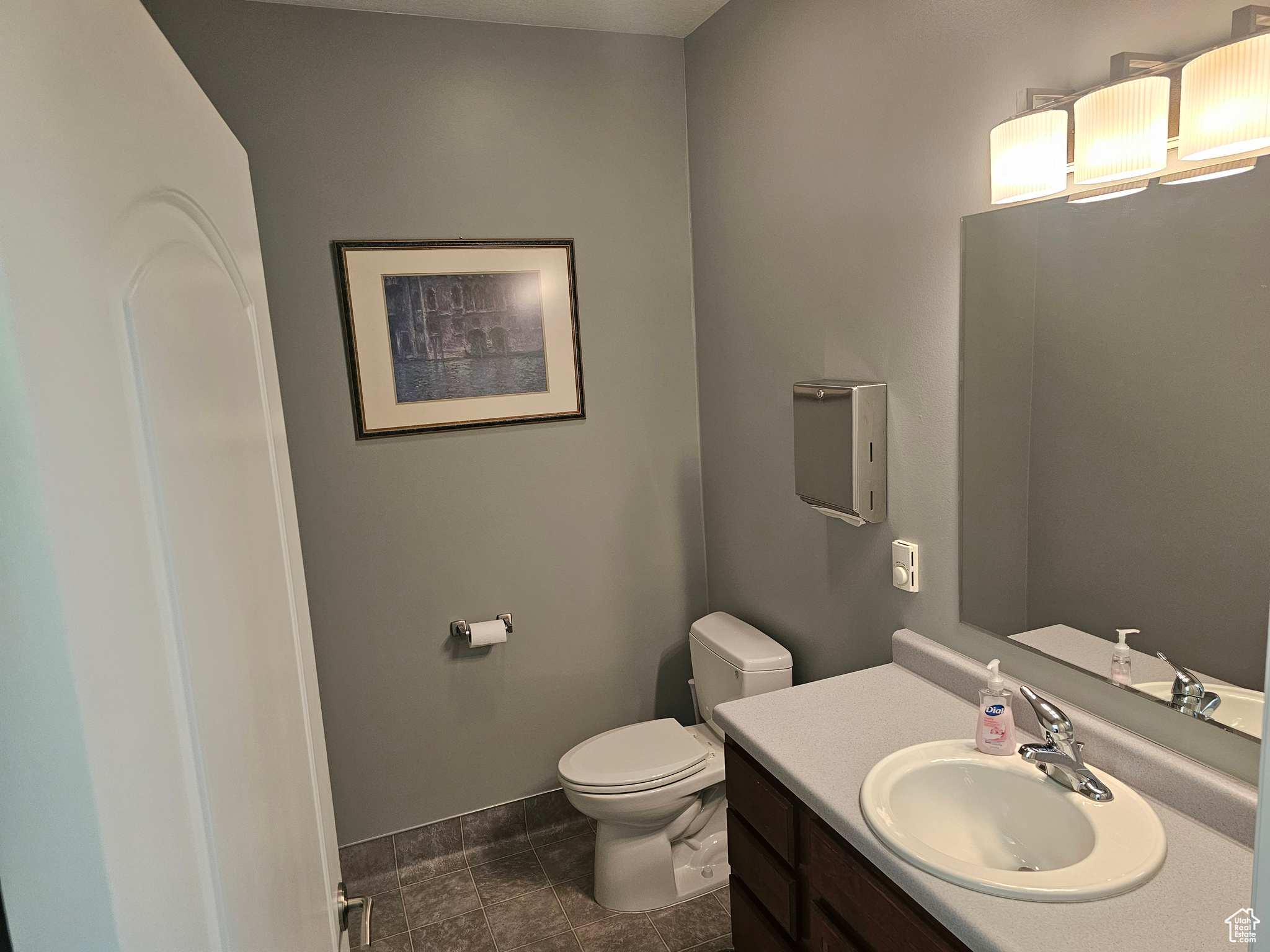 Bathroom featuring tile flooring, toilet, and vanity with extensive cabinet space