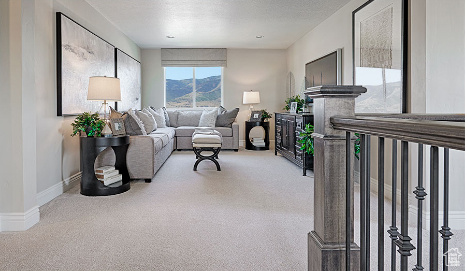 Living room with a textured ceiling, carpet floors, and a mountain view