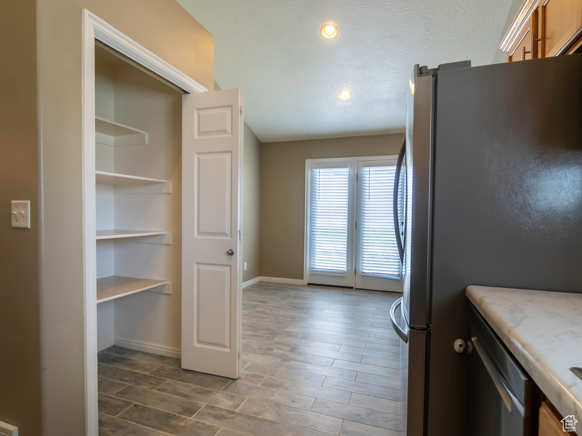 Kitchen featuring hardwood / wood-style flooring and stainless steel refrigerator