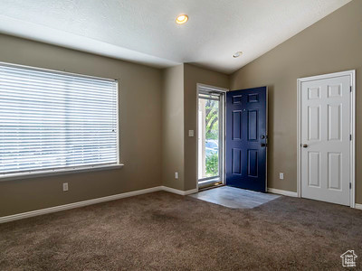 Foyer featuring carpet floors and lofted ceiling