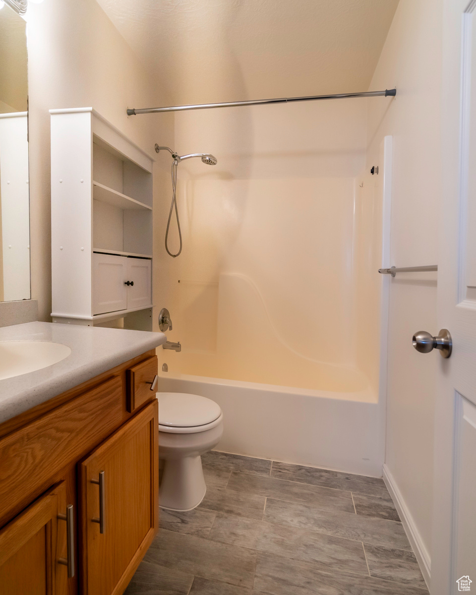 Full bathroom with tile floors, tub / shower combination, vanity, and toilet