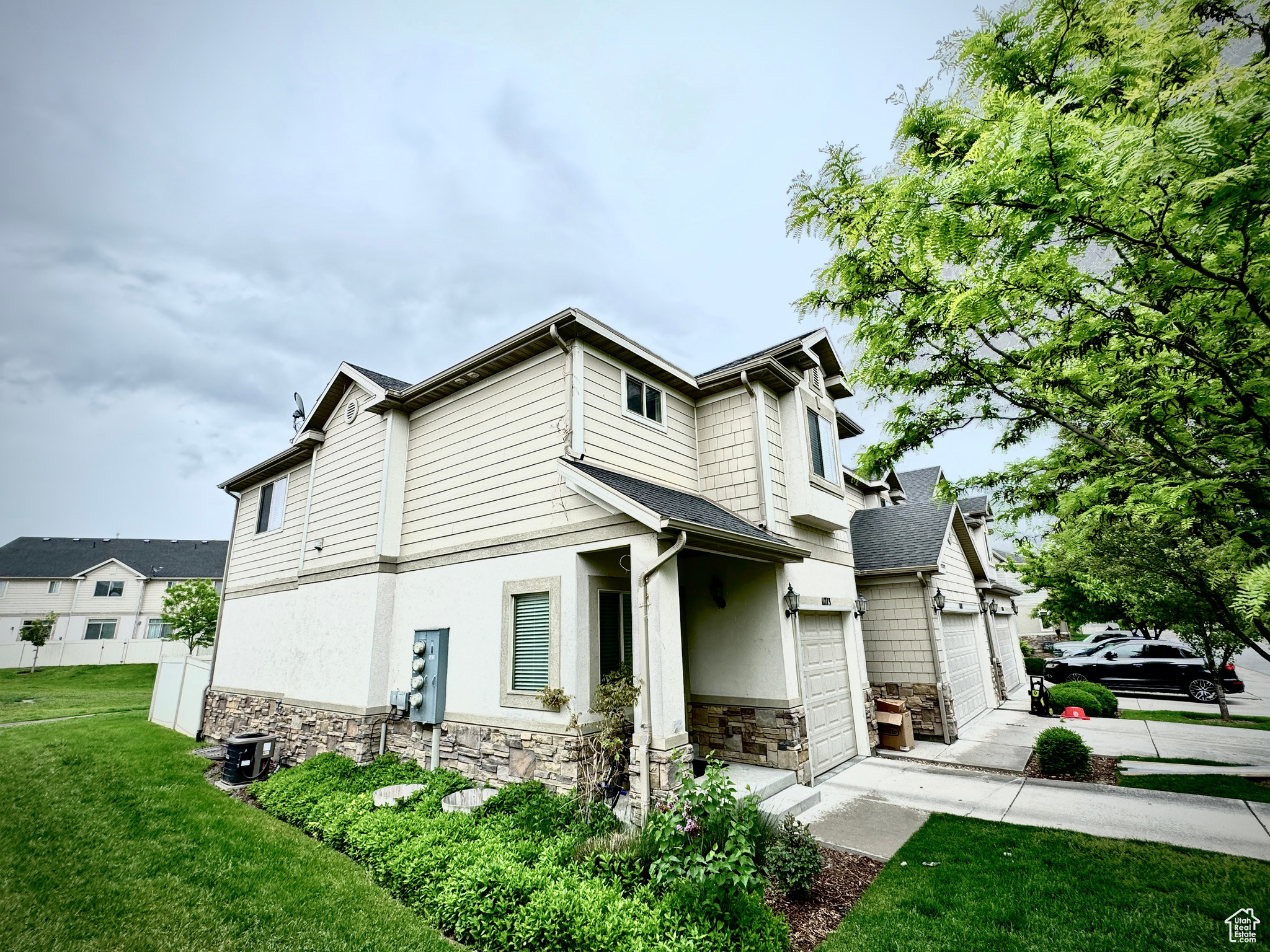 View of side of home featuring a garage and a yard