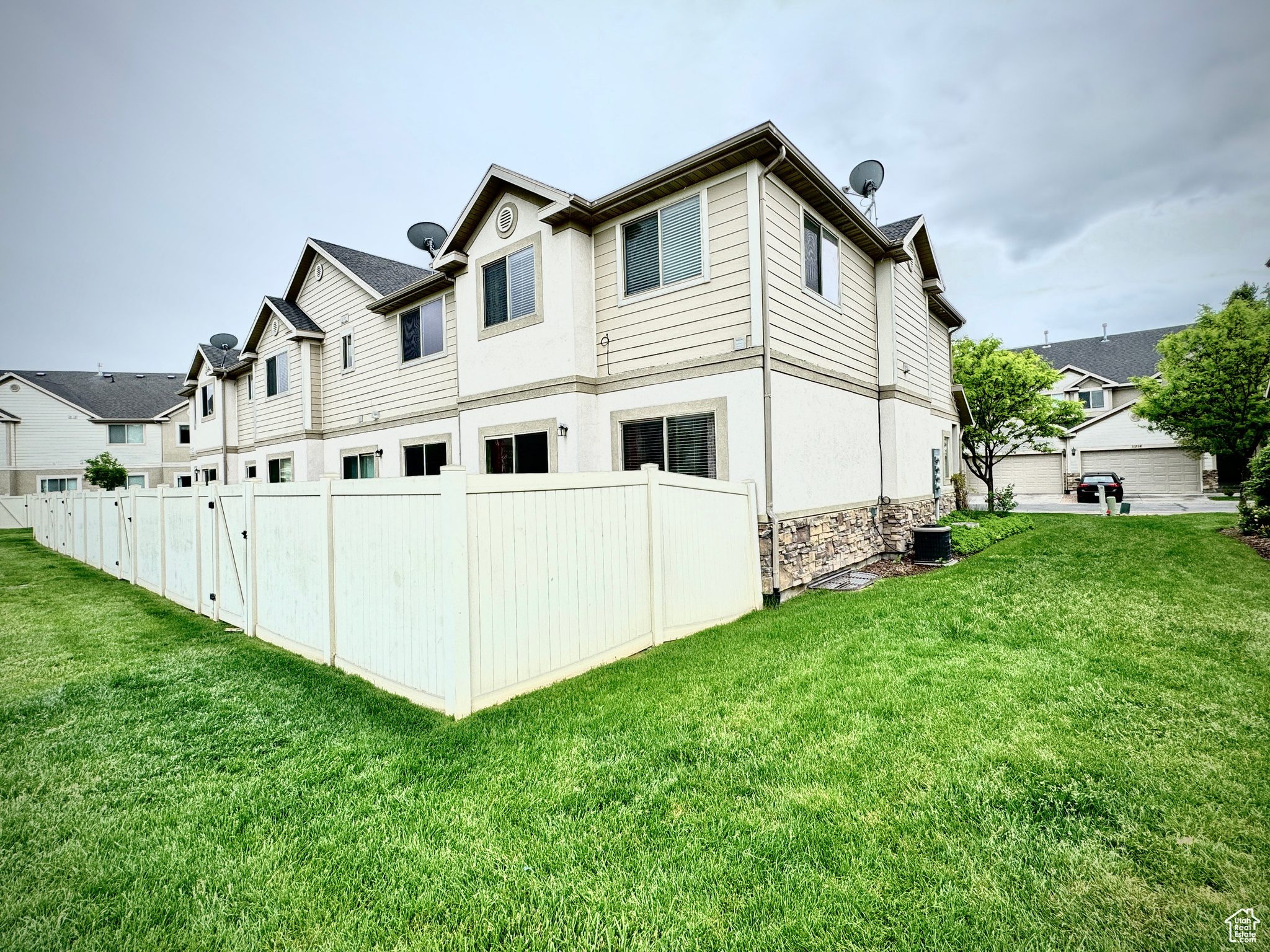 View of side of property with a garage and a lawn