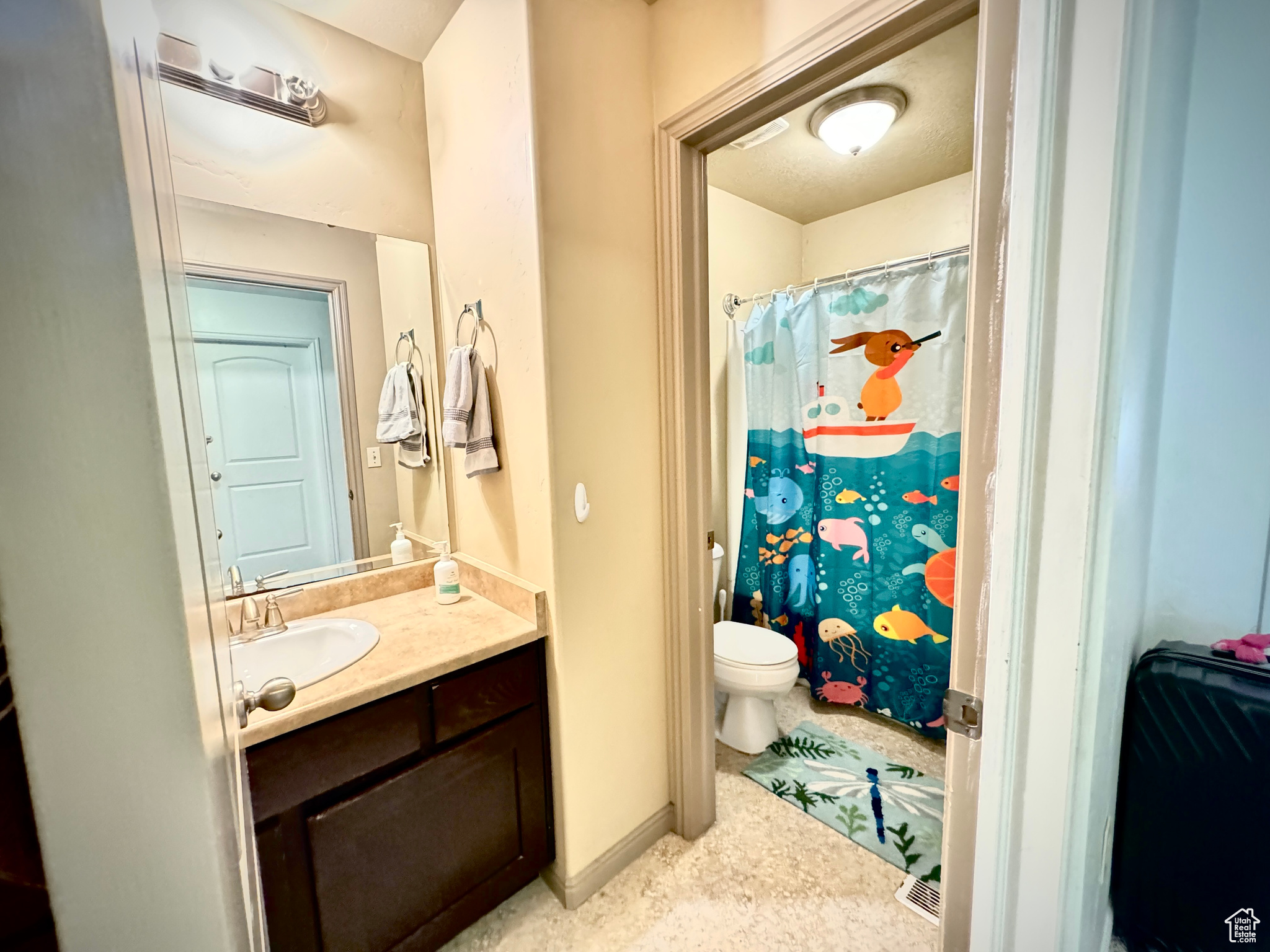 Bathroom with tile flooring, large vanity, and toilet