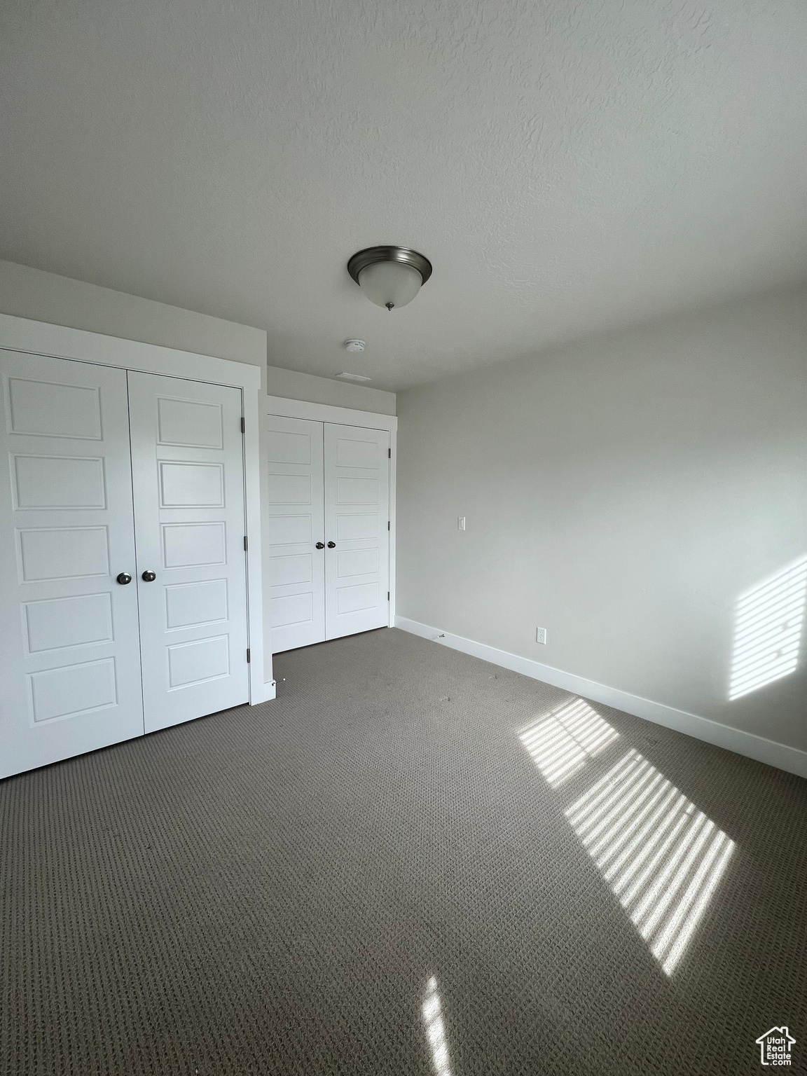 Bedroom with dark carpet and a textured ceiling