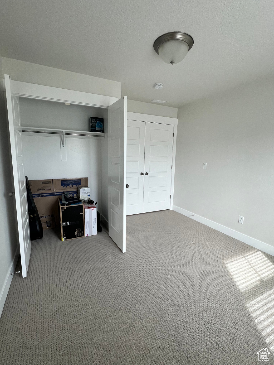 Carpeted bedroom with a closet