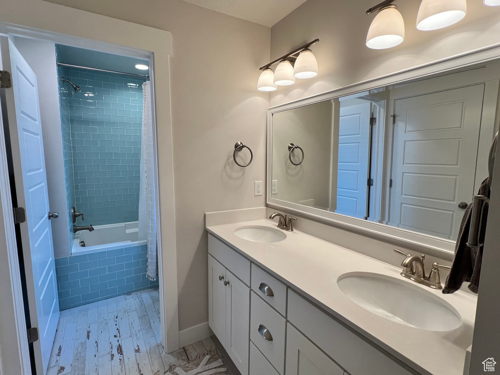 Main bathroom featuring large vanity, dual sinks, and shower / bath combo with shower curtain