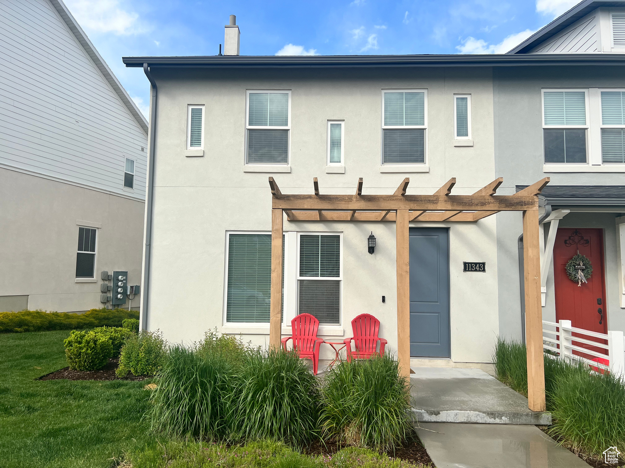 Townhome property with a front yard and a pergola