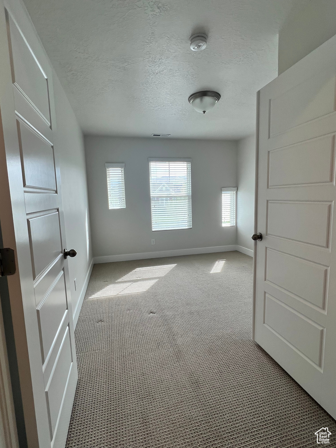 Bedroom carpeted empty room featuring double doors