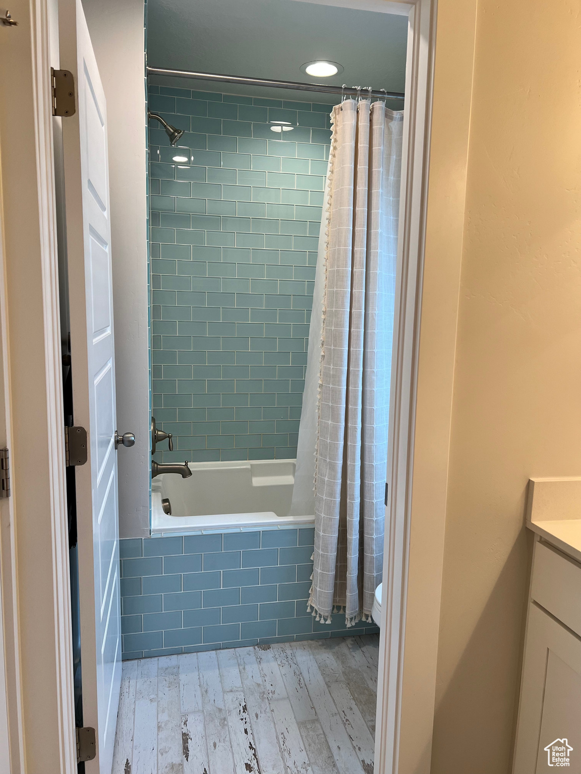 Main bathroom with toilet, shower / bath combination with curtain, vanity, and hardwood / wood-style flooring