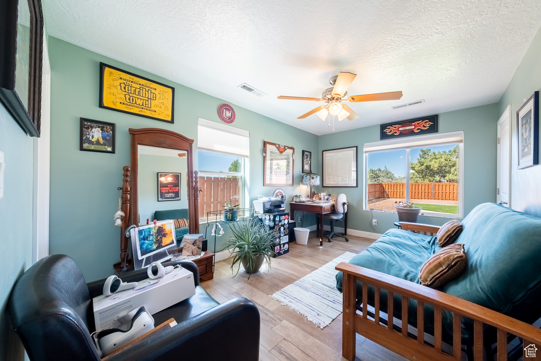 Living room featuring a textured ceiling, light wood-type flooring, and ceiling fan