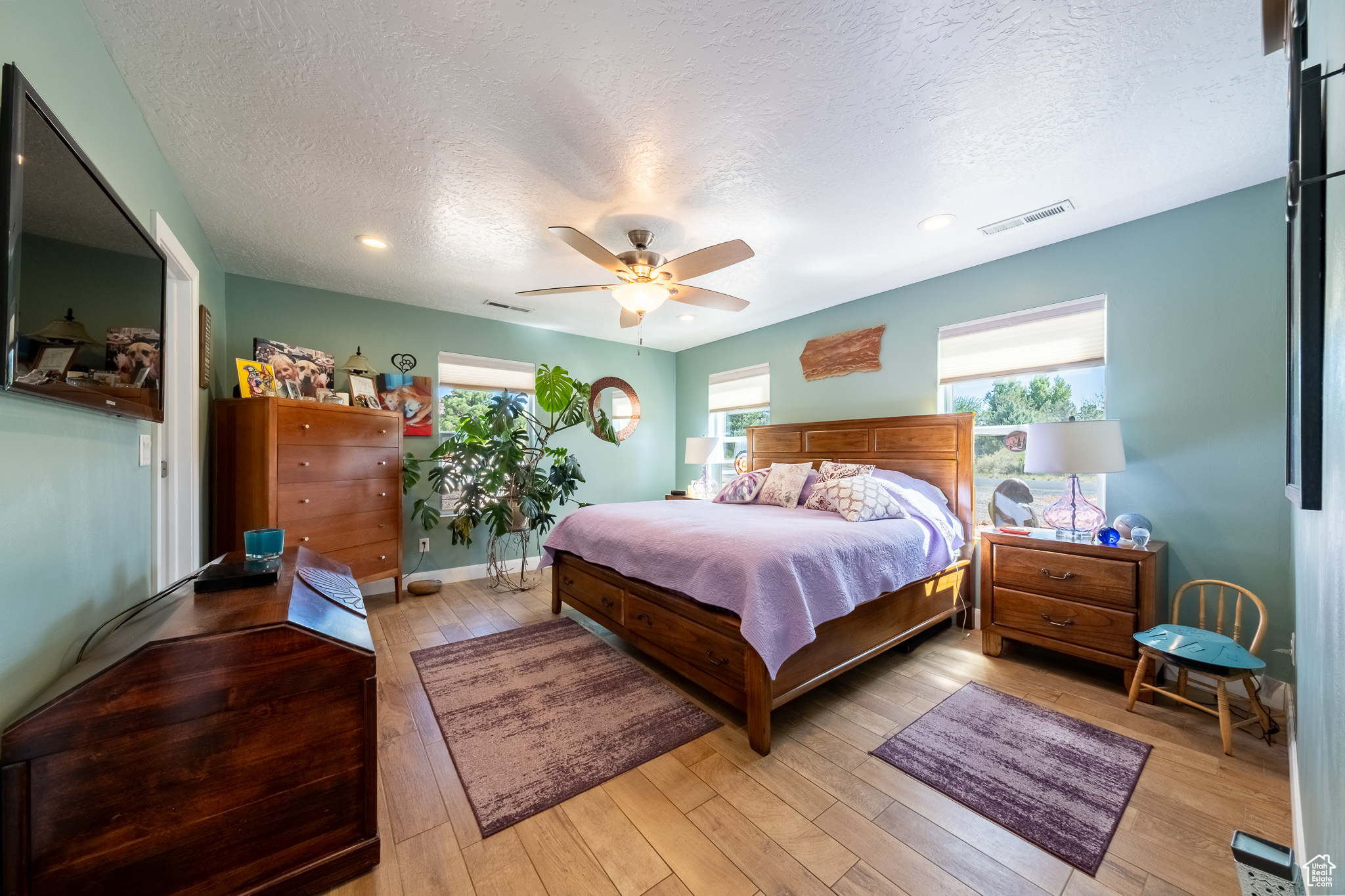 Bedroom featuring a textured ceiling, ceiling fan, and hardwood / wood-style floors