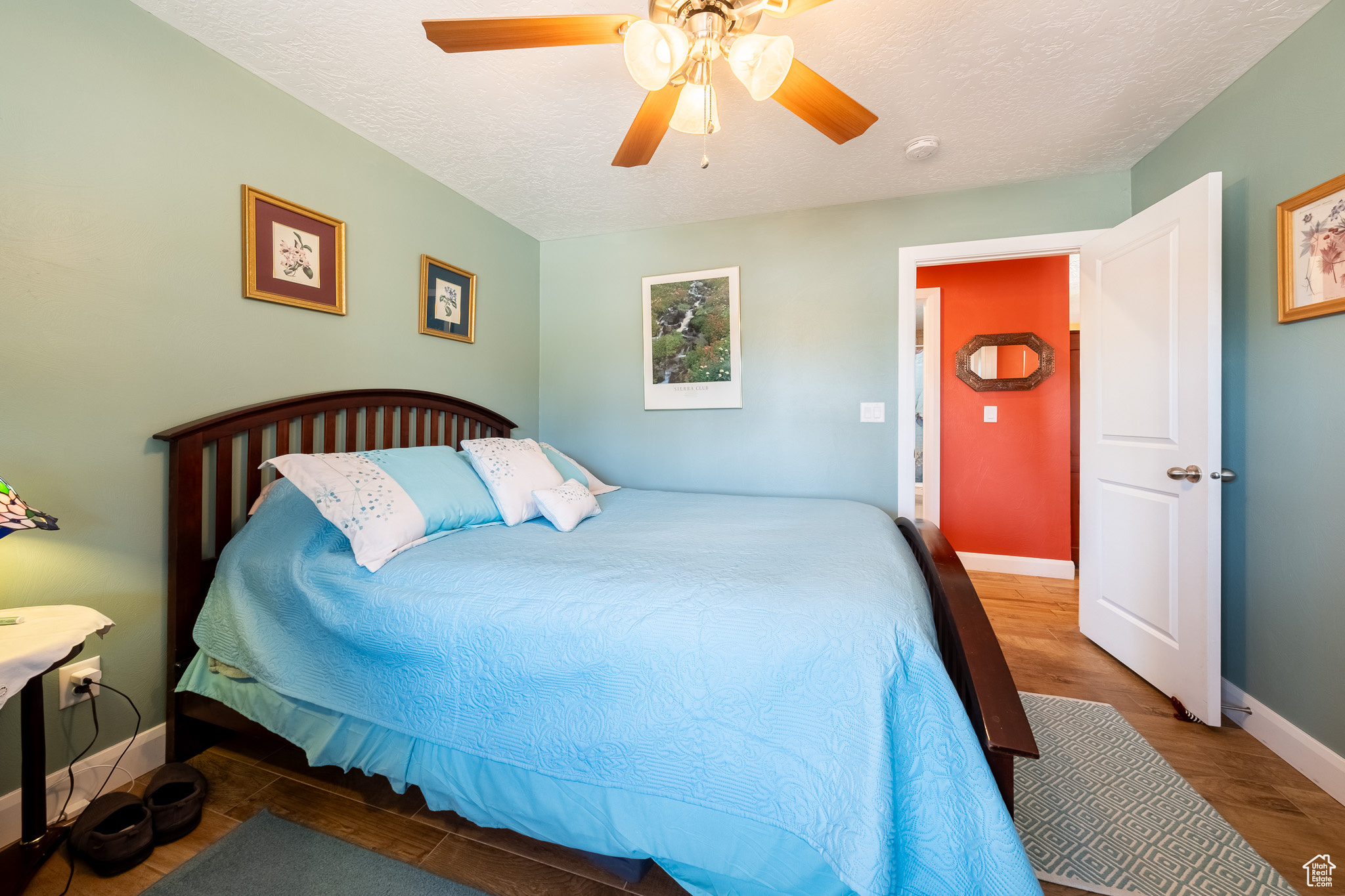 Bedroom featuring a textured ceiling, ceiling fan, and hardwood / wood-style floors