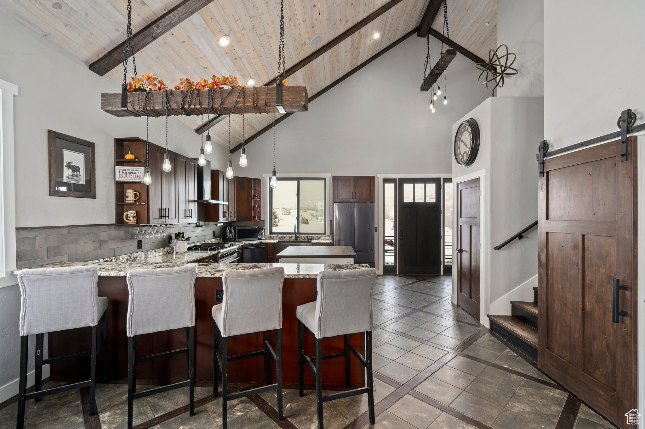 Kitchen with a barn door, high vaulted ceiling, beam ceiling, and wood ceiling