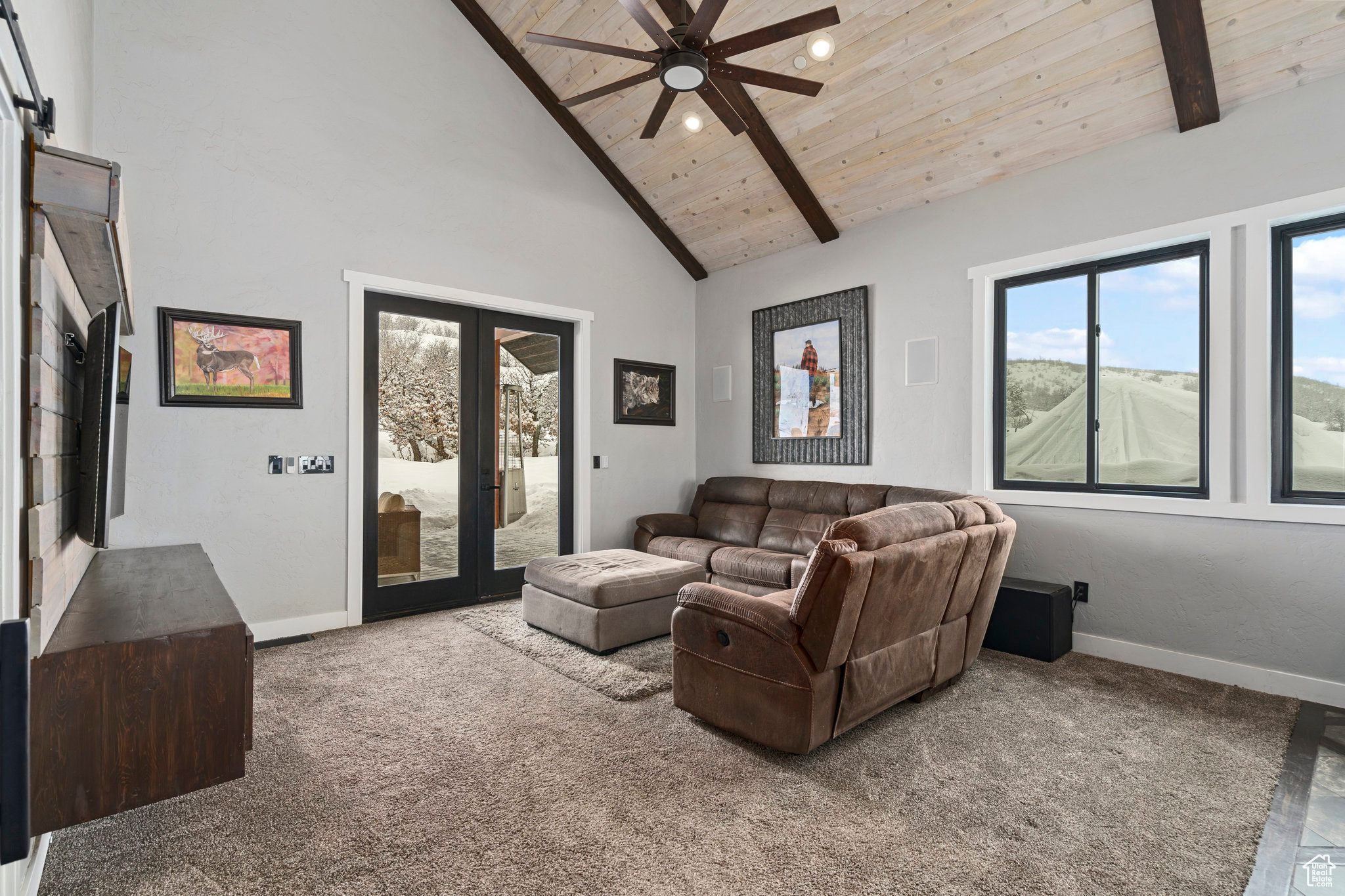 Carpeted living room featuring high vaulted ceiling, beamed ceiling, ceiling fan, and wood ceiling