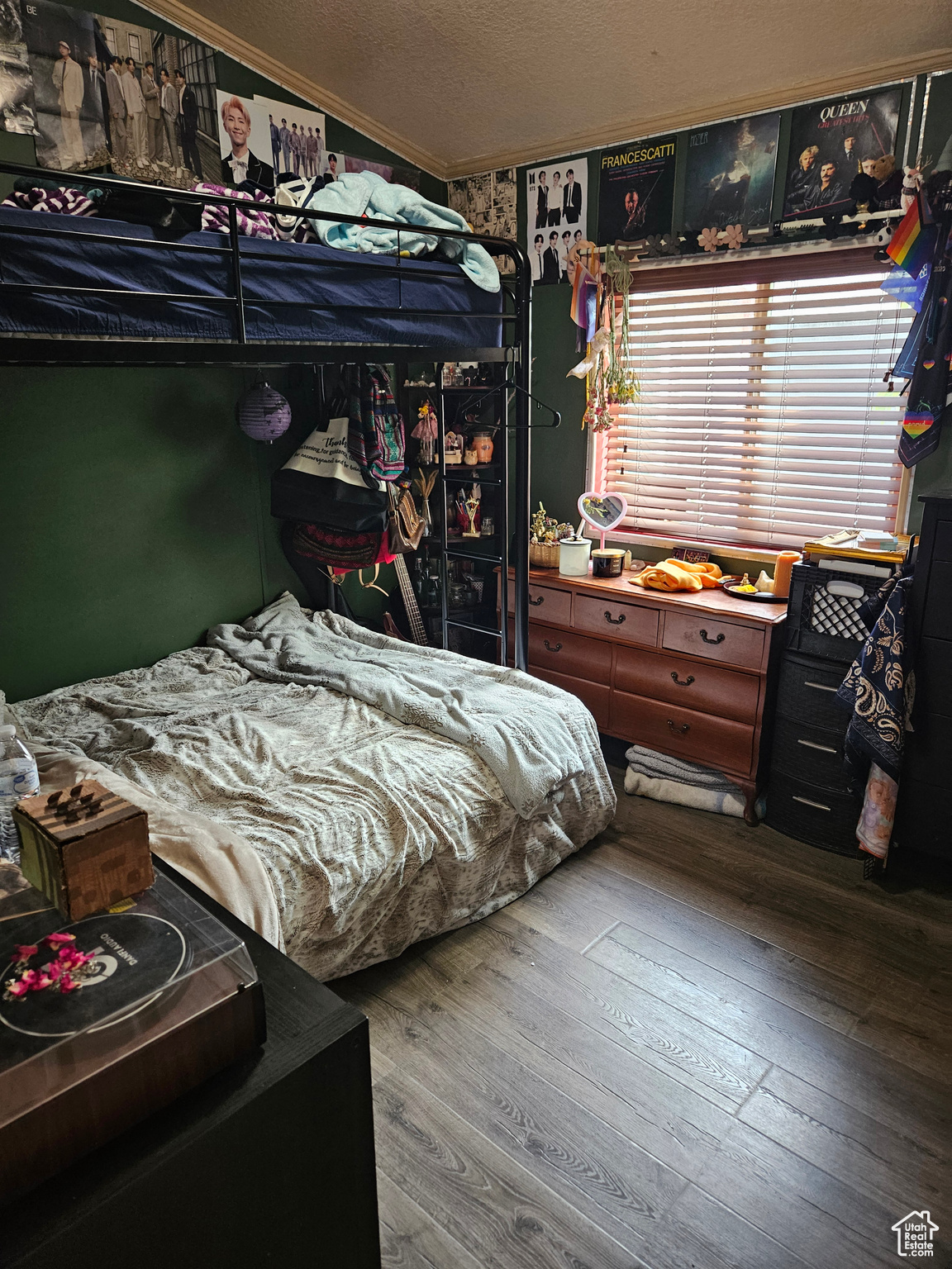 Bedroom with a textured ceiling, ornamental molding, and wood-type flooring