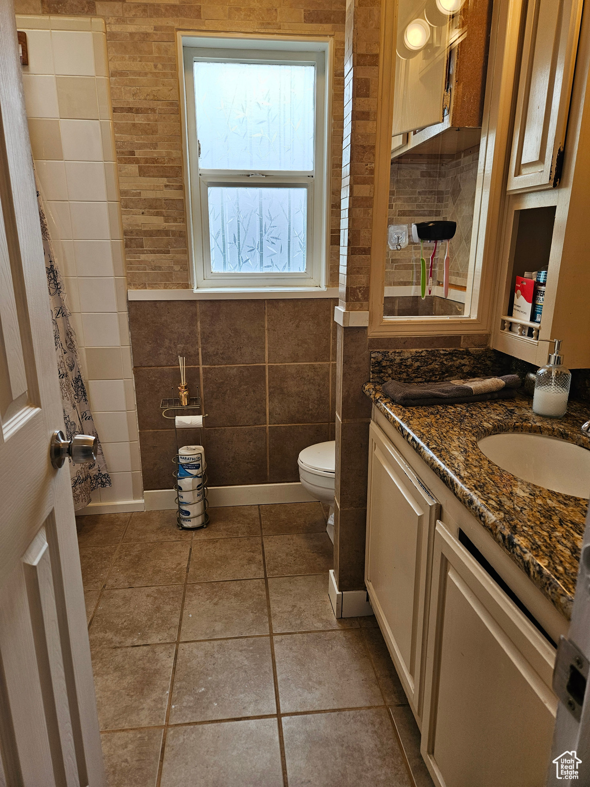 Bathroom with tile flooring, a wealth of natural light, toilet, and vanity