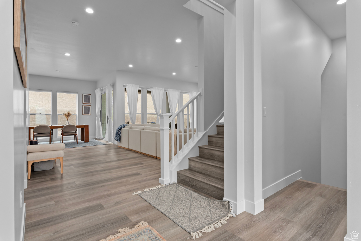 Staircase with a wealth of natural light and light wood-type flooring