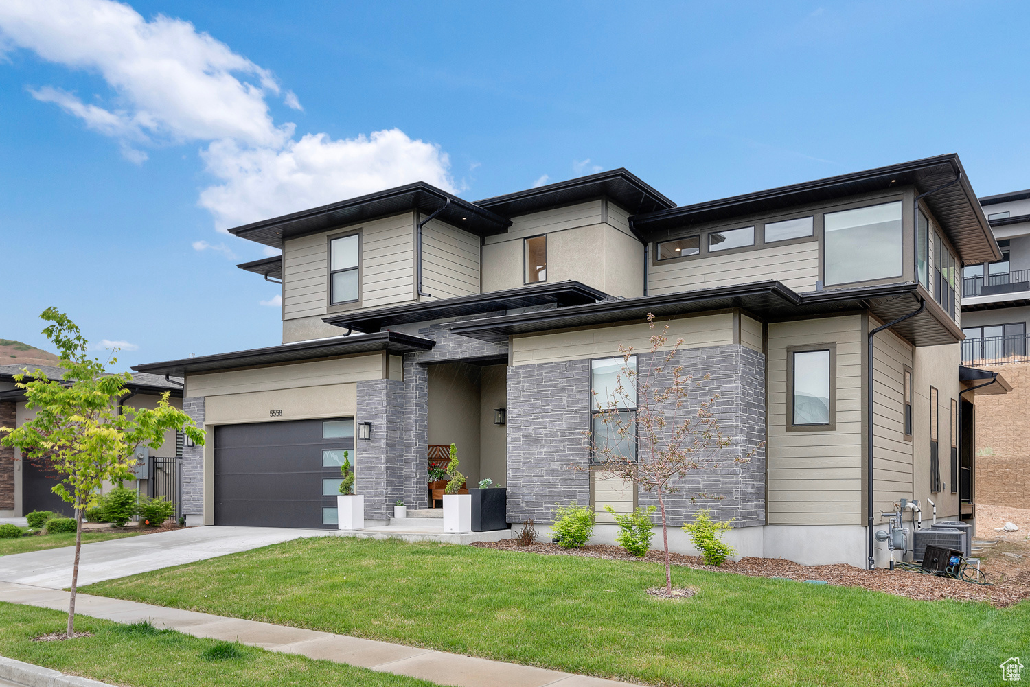 Prairie-style home with a garage, central AC, and a front lawn