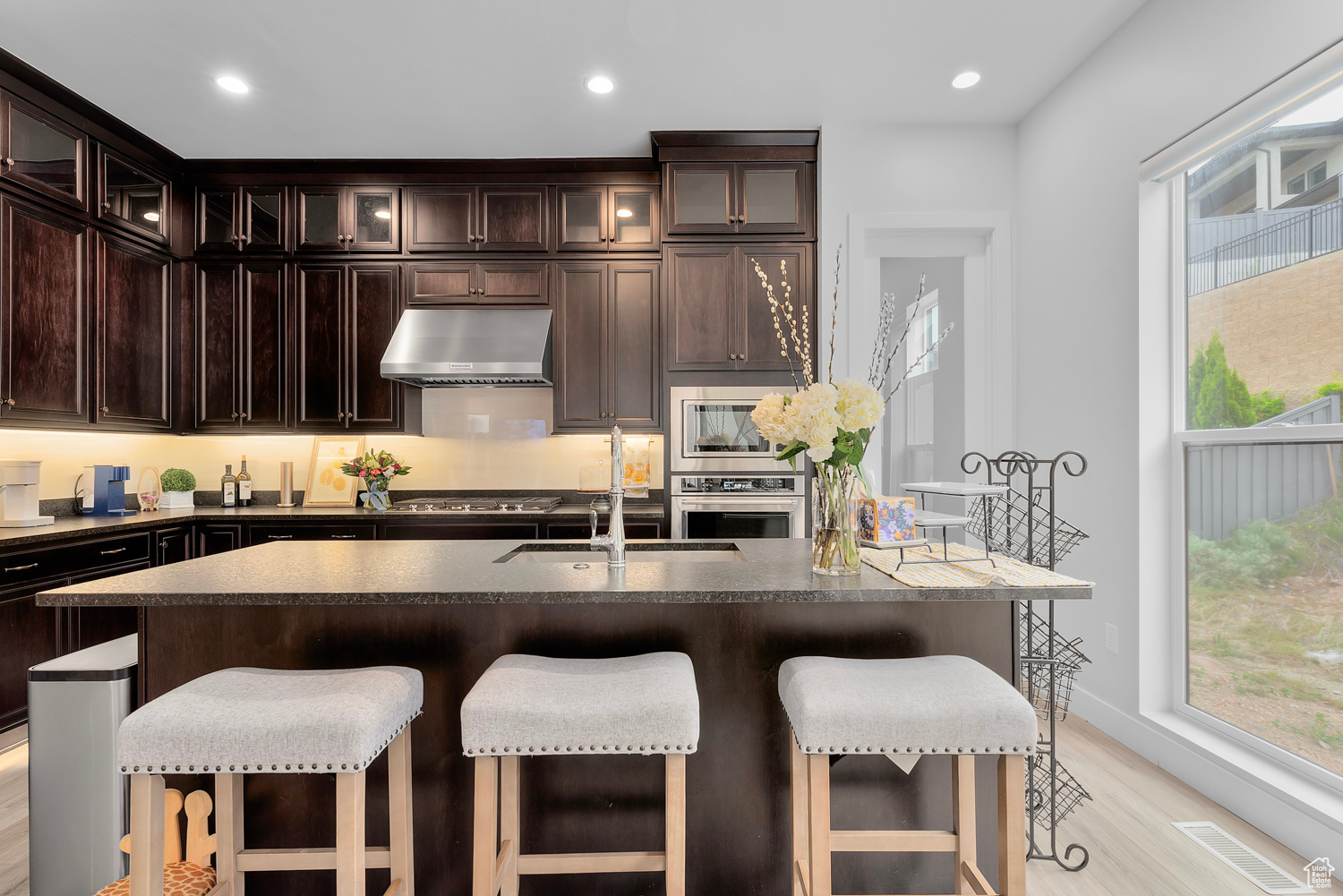 Kitchen featuring dark brown cabinets, a center island with sink, light hardwood / wood-style flooring, and sink