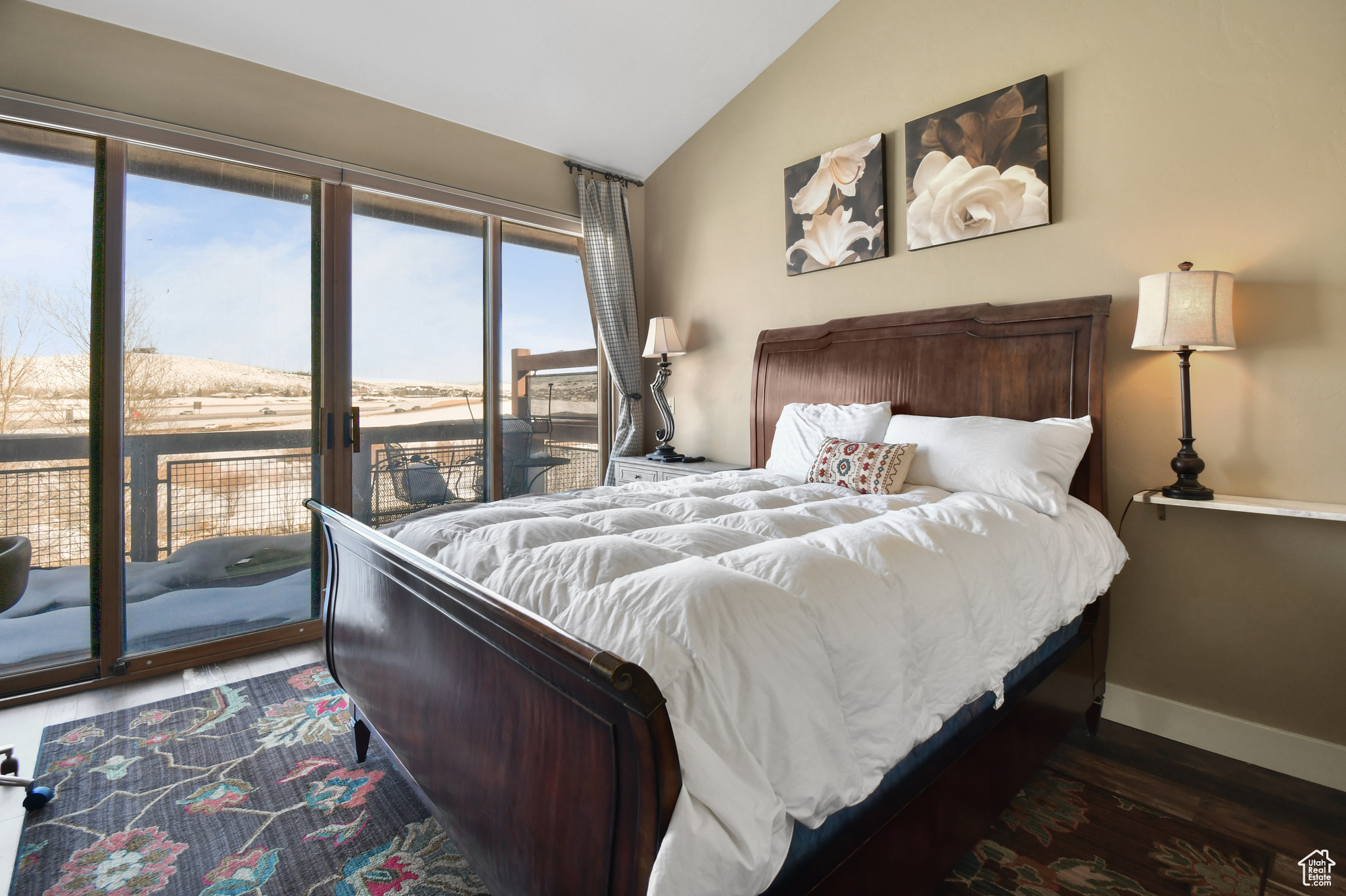 Bedroom with dark hardwood / wood-style flooring, access to outside, and vaulted ceiling