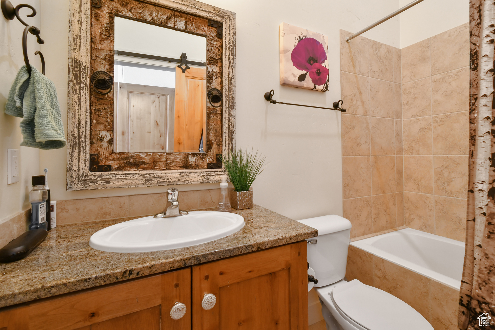 Full bathroom featuring tiled shower / bath, vanity, and toilet