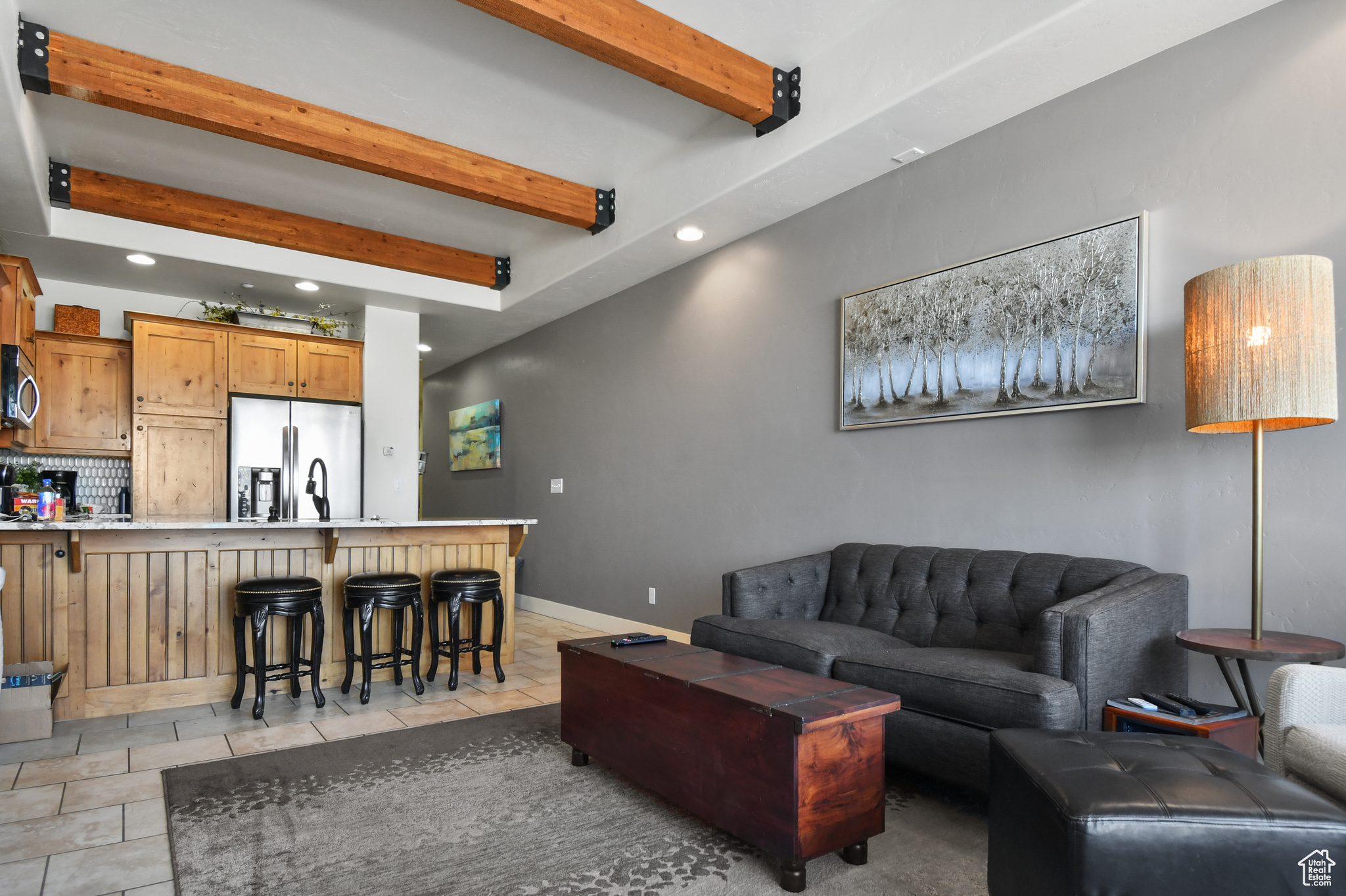 Living room featuring beam ceiling and light tile flooring