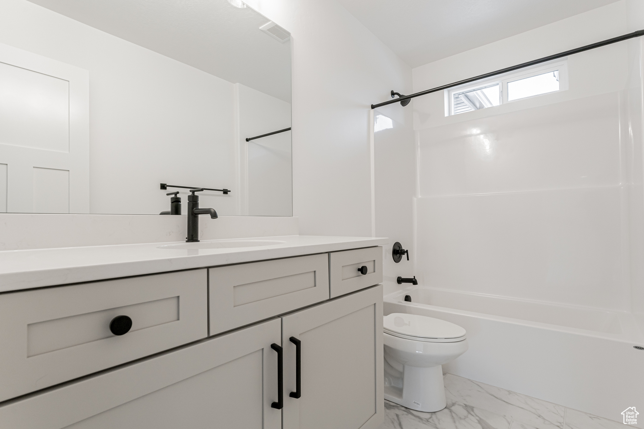 Full bathroom with vanity, toilet, and  shower combination