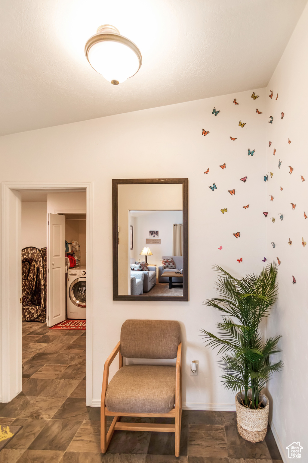 Living area featuring tile flooring, washer / clothes dryer, and vaulted ceiling