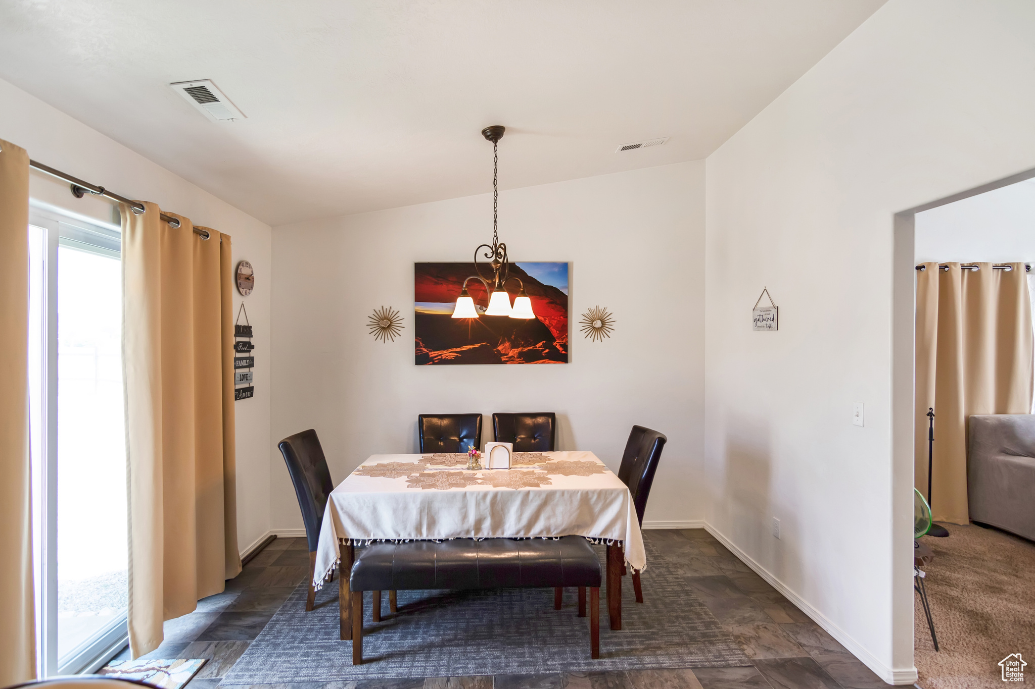 Carpeted dining room featuring a notable chandelier and vaulted ceiling