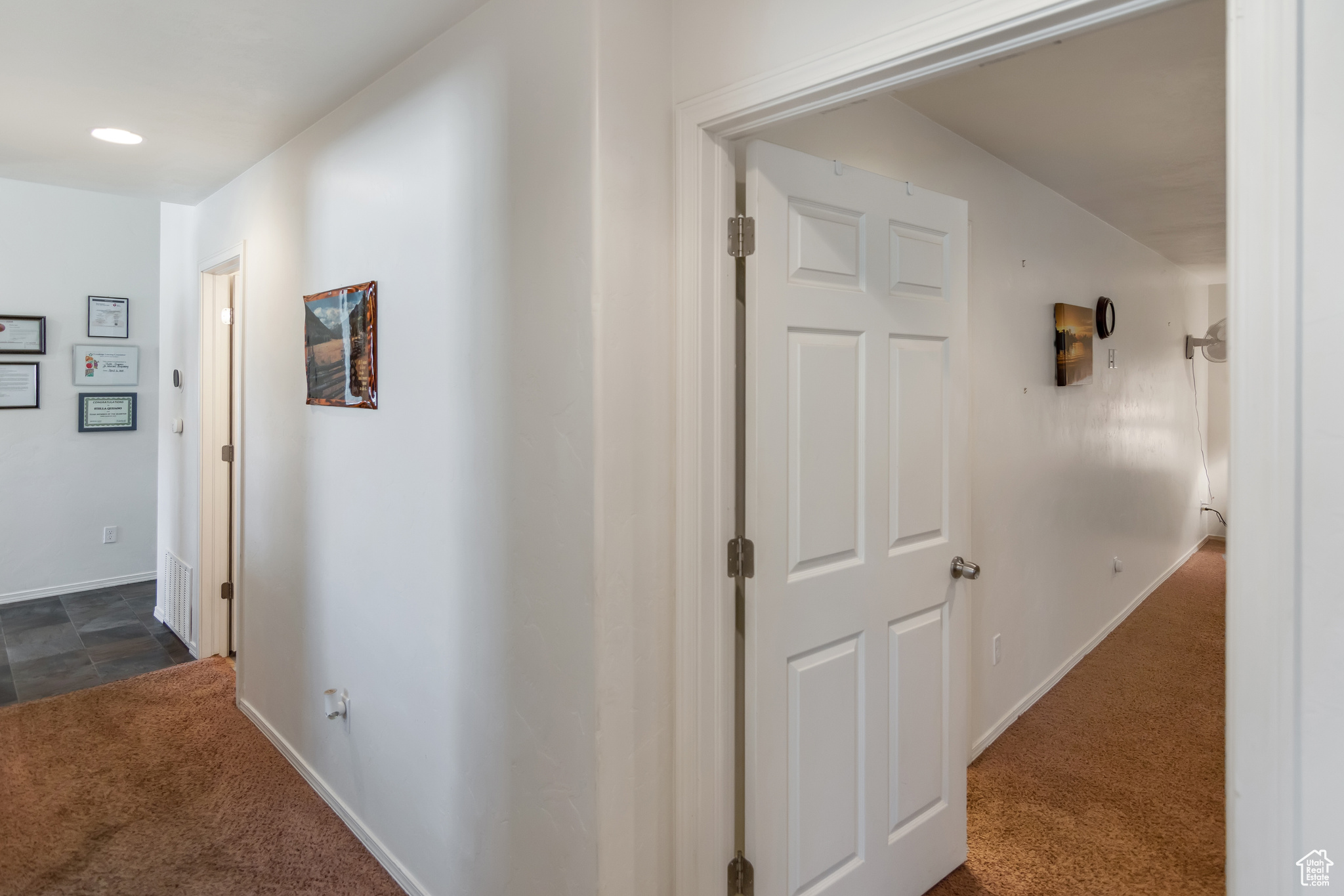 Hallway featuring dark carpet