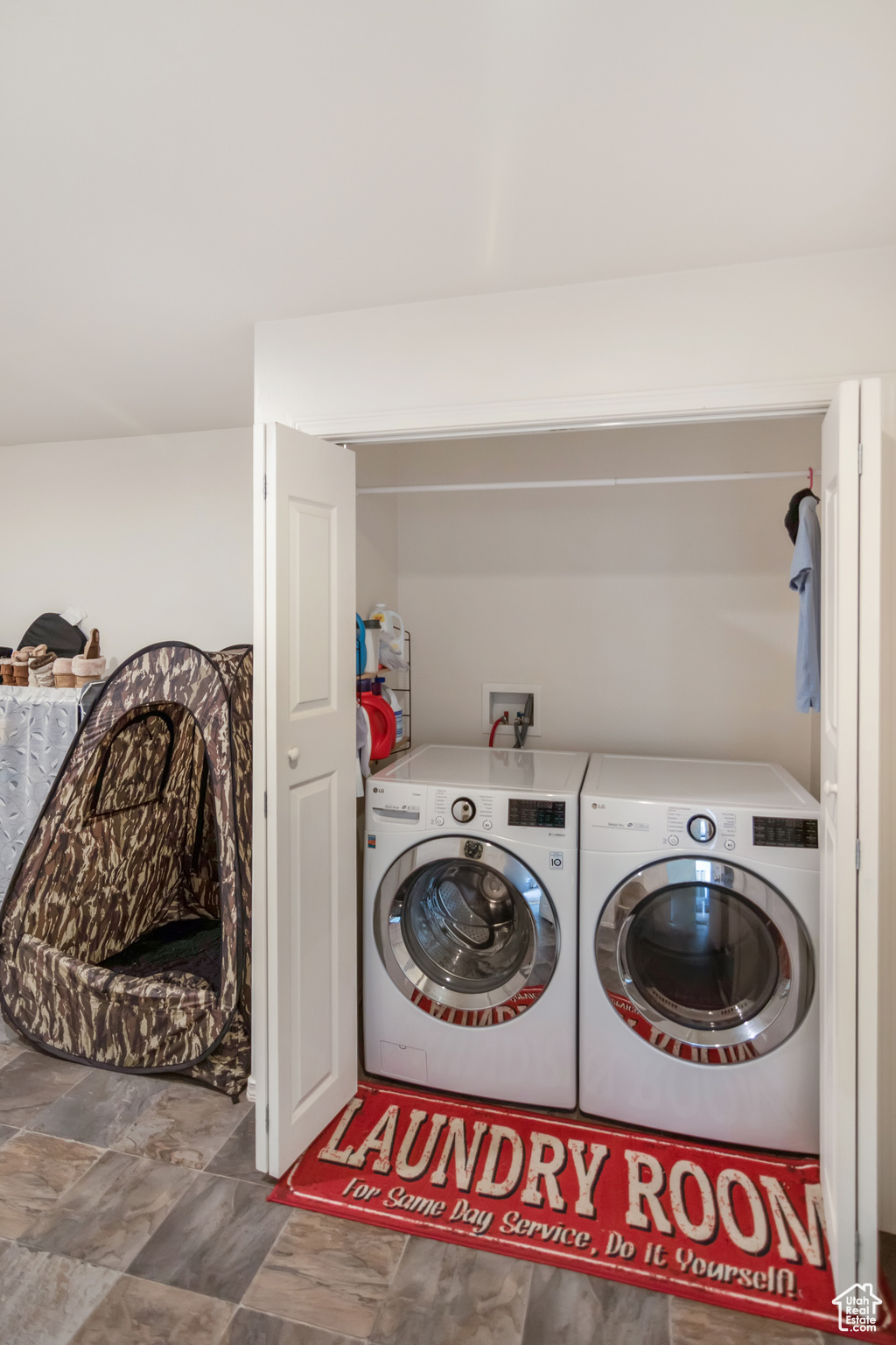 Clothes washing area featuring tile floors, hookup for a washing machine, and washer and dryer