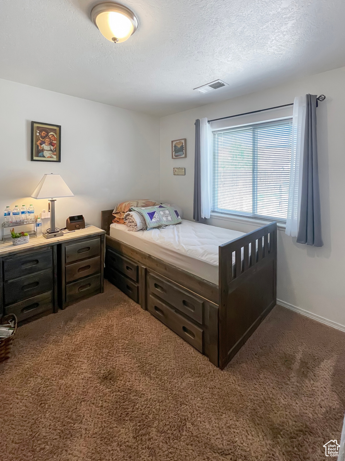 Bedroom featuring a textured ceiling and carpet flooring