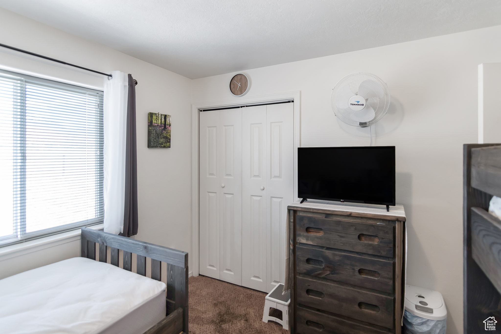 Bedroom with a closet, multiple windows, and dark carpet