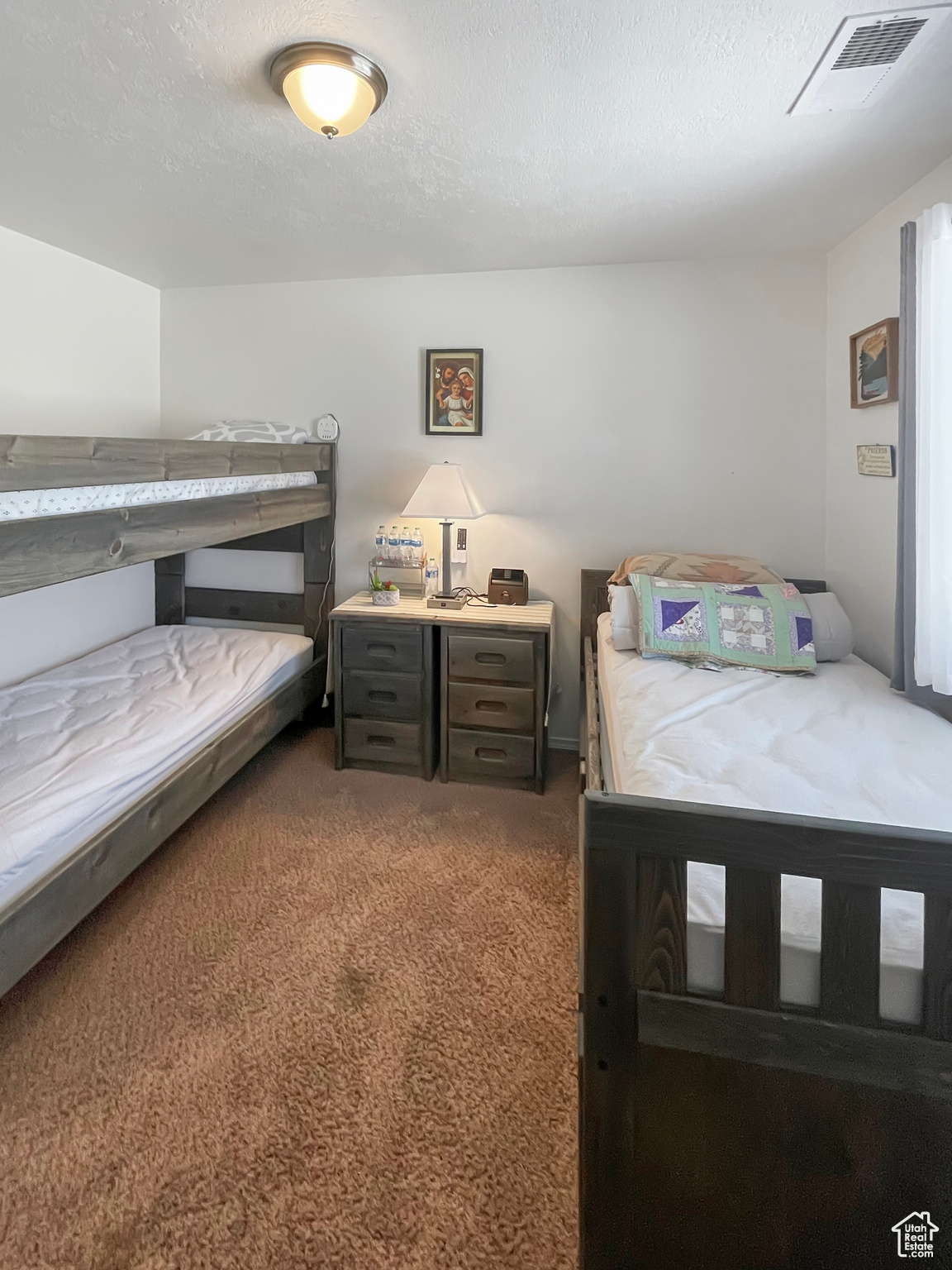 Bedroom with a textured ceiling and carpet floors