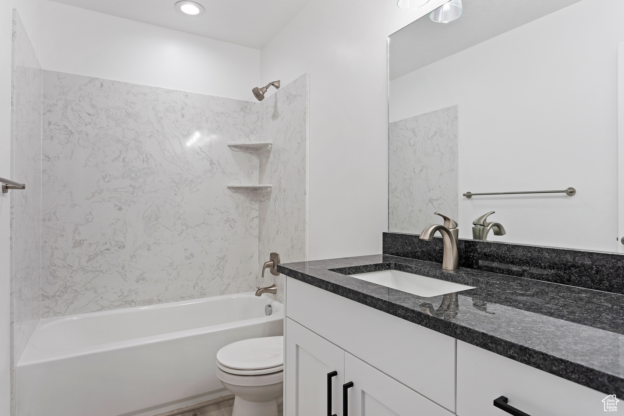 Full bathroom with tiled shower / bath, toilet, and vanity with extensive cabinet space