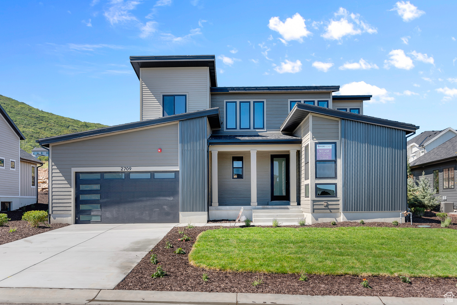 Modern home featuring a garage and a front lawn