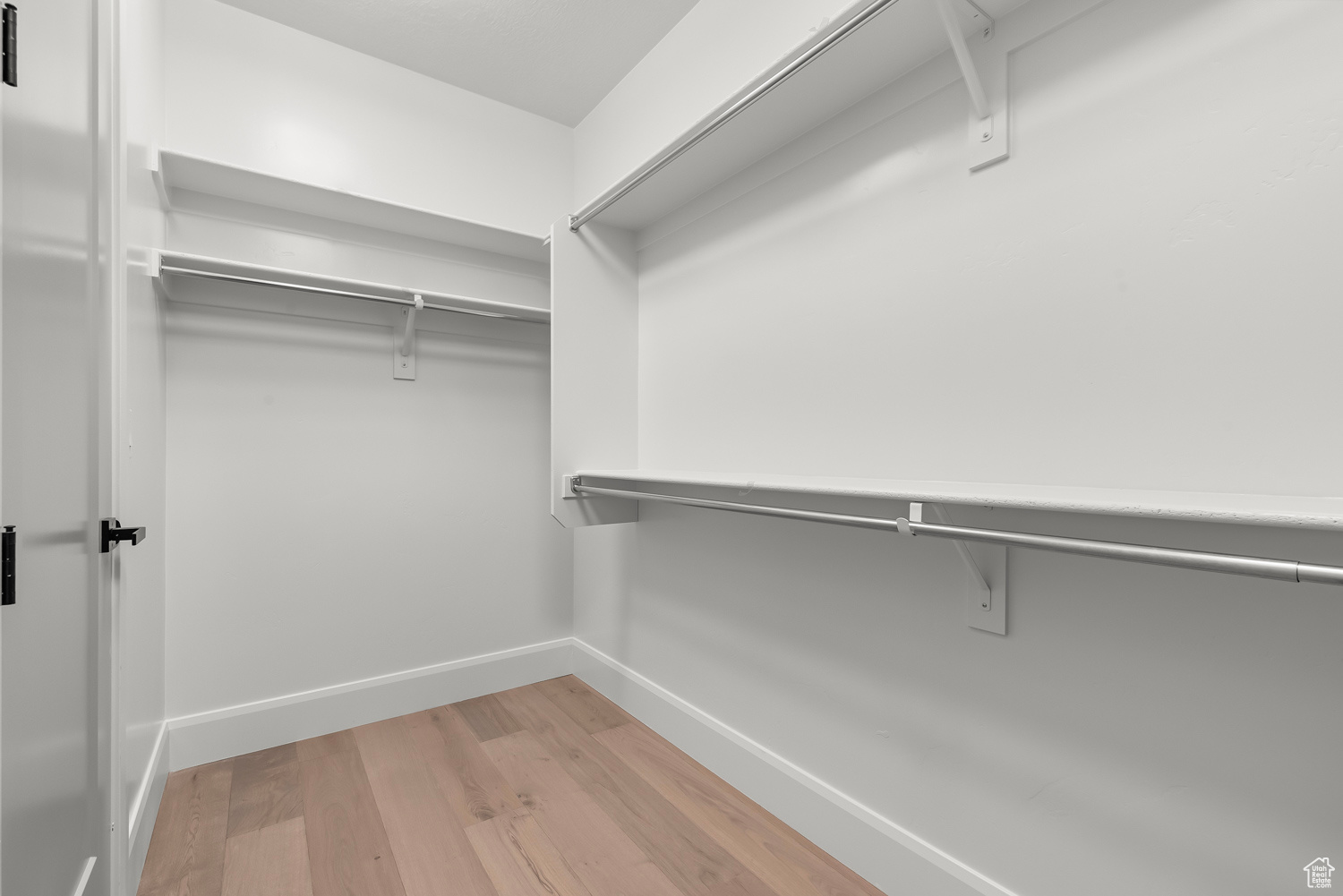 Walk in closet with light wood-type flooring