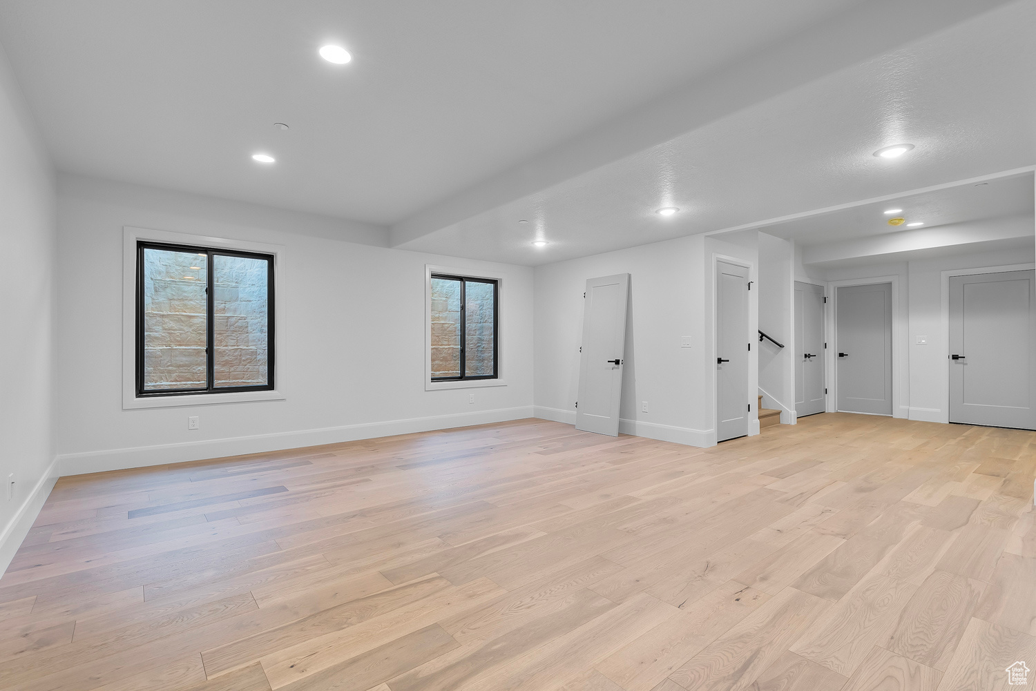 Interior space with light wood-type flooring and a healthy amount of sunlight