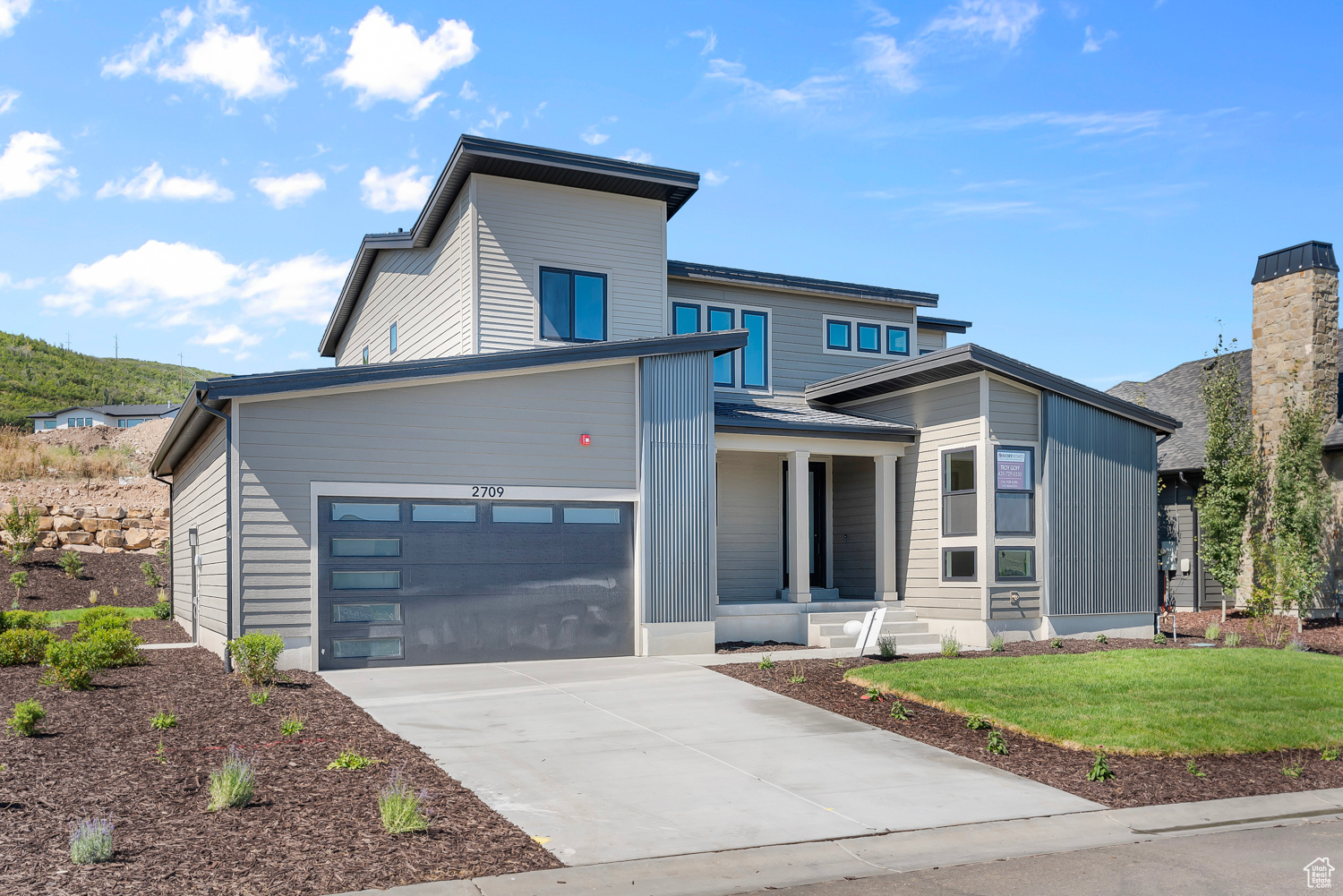 Contemporary home featuring a front yard and a garage