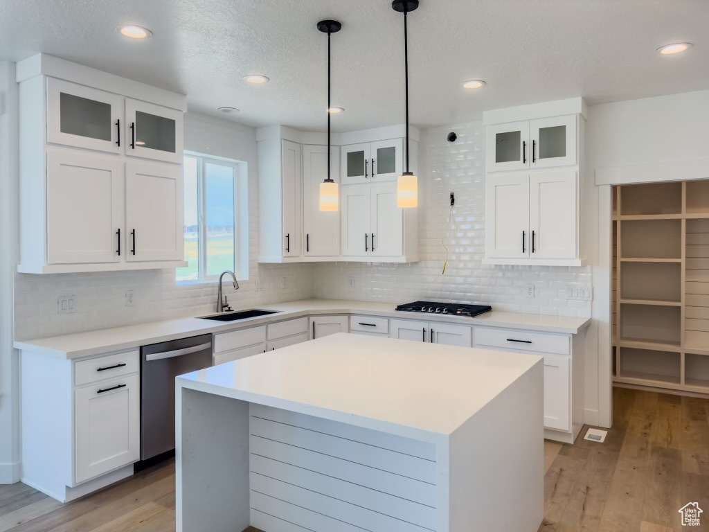 Kitchen with white cabinets, dishwasher, light wood-type flooring, and sink