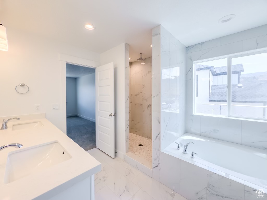 Bathroom with tile patterned flooring, separate shower and tub, and dual bowl vanity