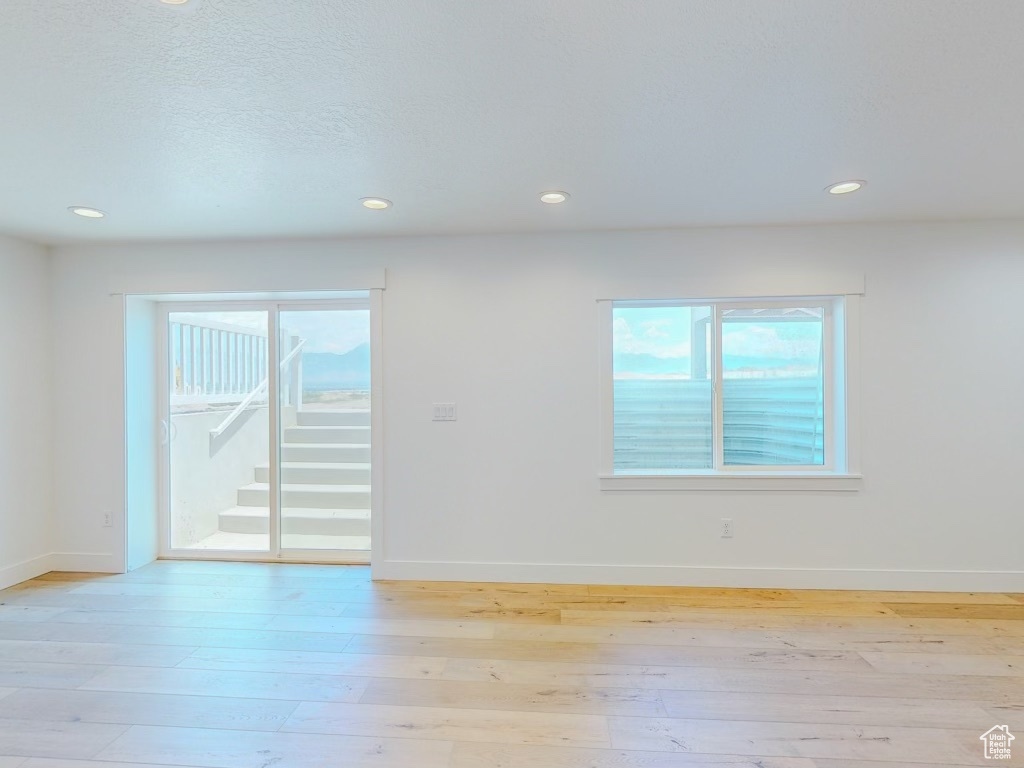 Empty room with light hardwood / wood-style floors