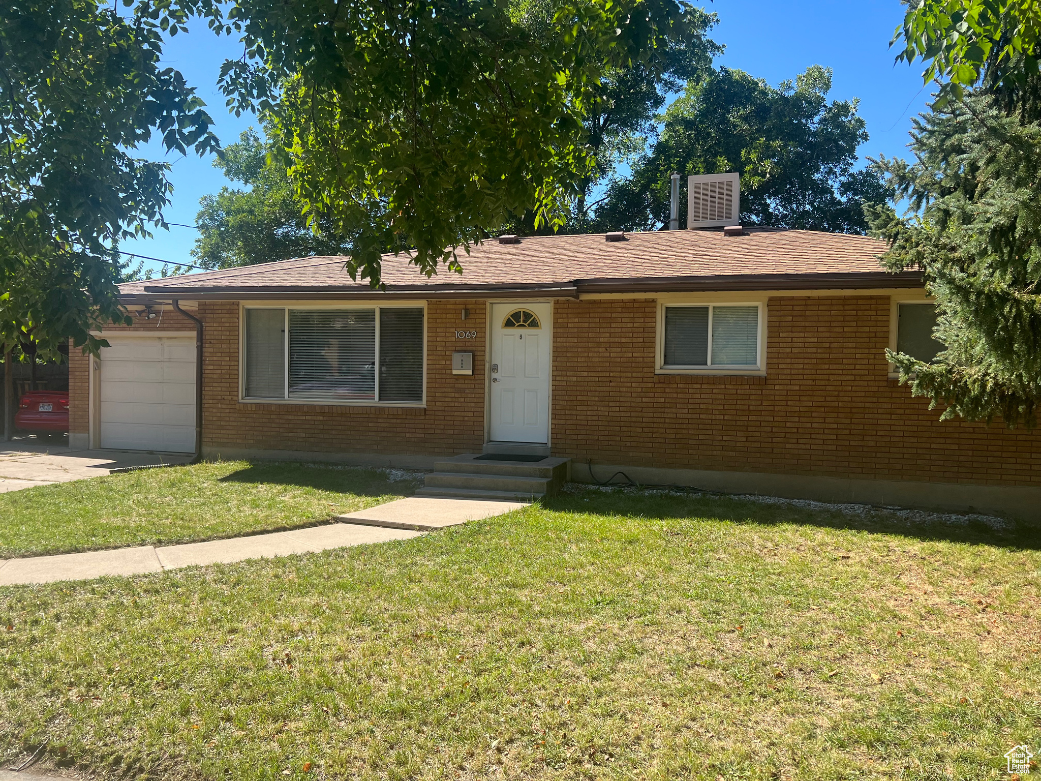 Single story home featuring a garage and a front yard