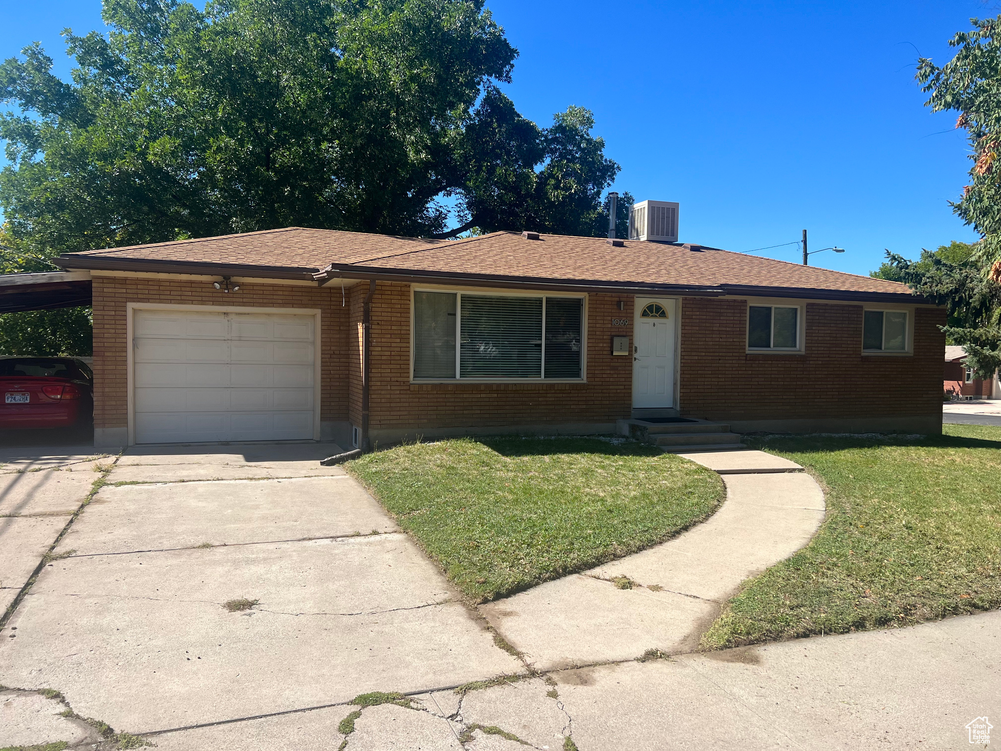 Ranch-style house with a garage and a front lawn