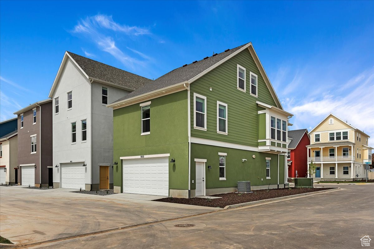 View of property exterior with a garage and central AC unit