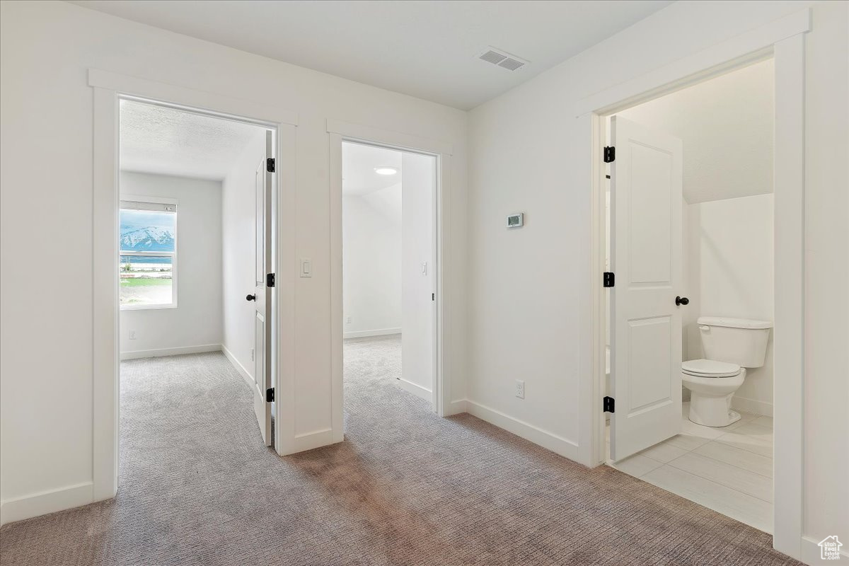 Hallway with tile flooring