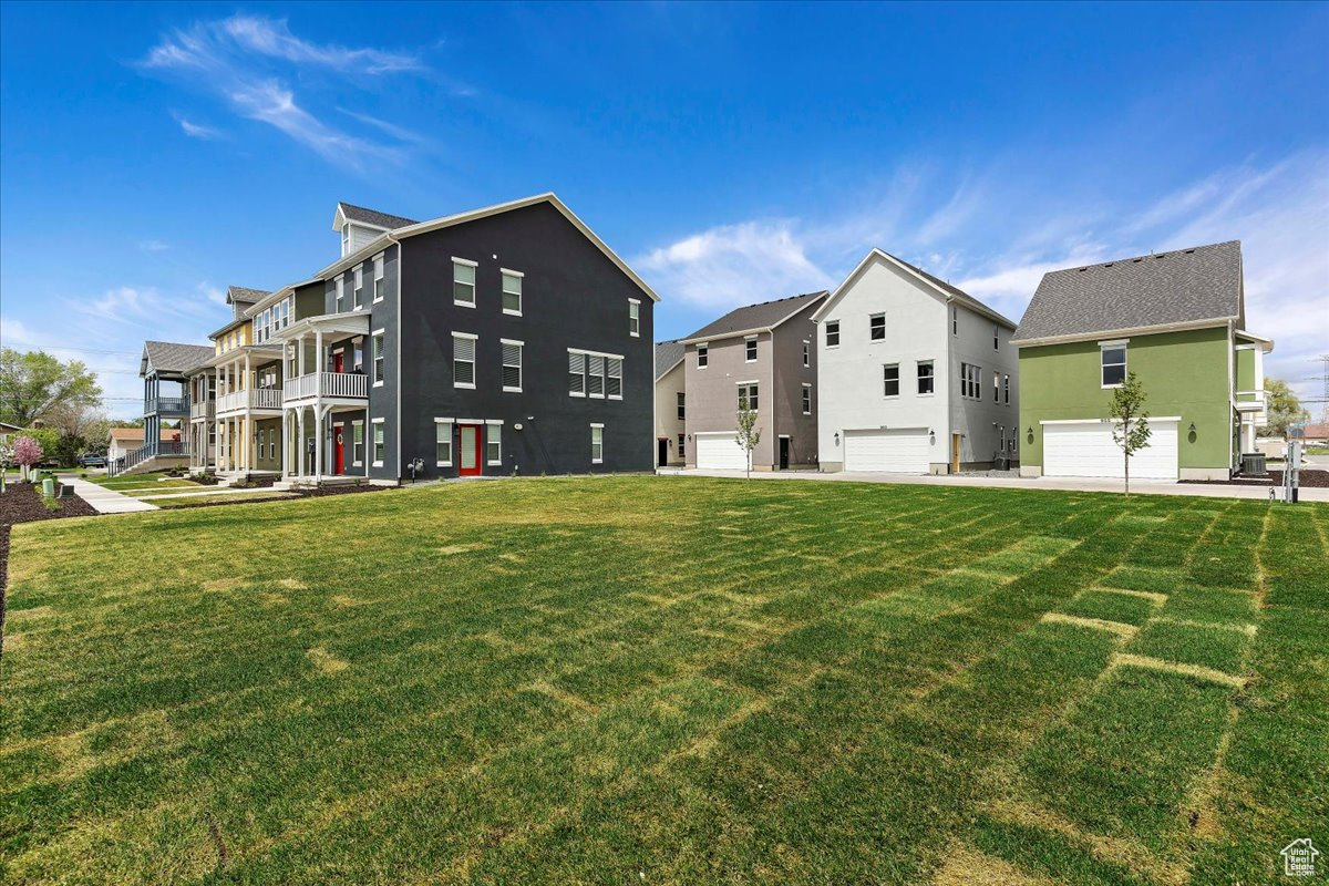 Exterior space featuring a garage, a balcony, and a yard