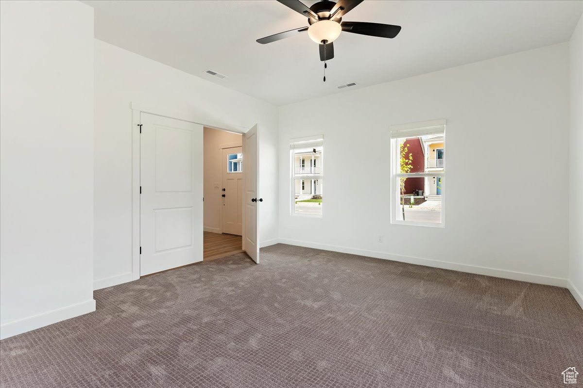 Interior space featuring ceiling fan and carpet floors